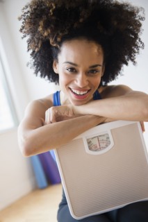 Mixed race woman holding scale