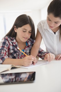 Caucasian twin sisters doing homework