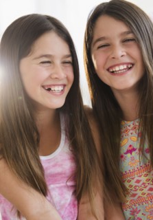 Caucasian twin sisters smiling