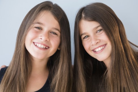 Caucasian twin sisters smiling