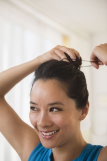 Chinese woman tying her hair in bun