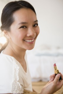 Chinese woman applying lipstick