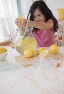 Girl squeezing lemons for lemonade