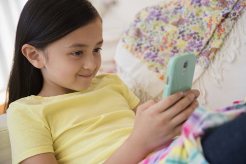 Smiling girl using cell phone