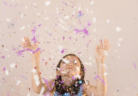 Girl tossing confetti in air