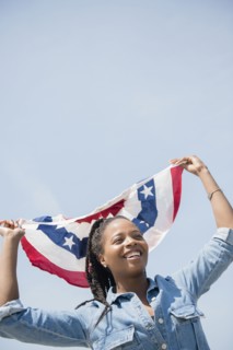 Black woman carrying American flag banner