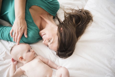 Mother laying with baby daughter