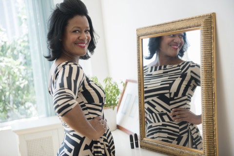 Black woman smiling near mirror