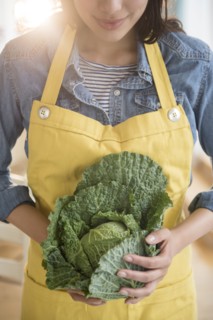 Hispanic woman holding head of lettuce