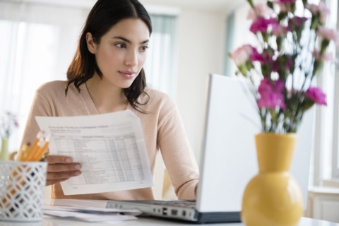 Hispanic woman paying bills on laptop