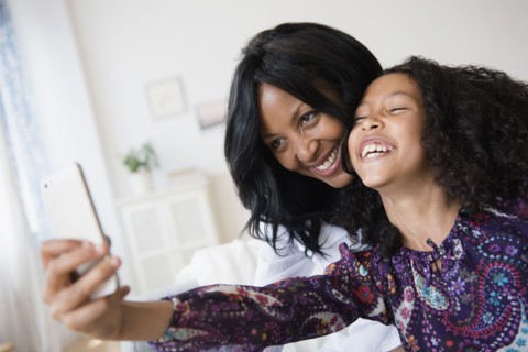 Mother and daughter taking selfie with cell phone