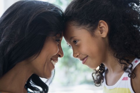 Mother and daughter touching foreheads