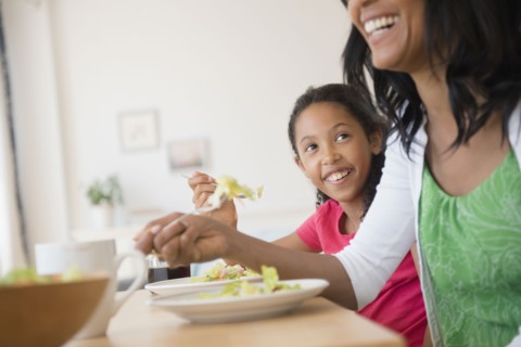 Mother and daughter eating salad