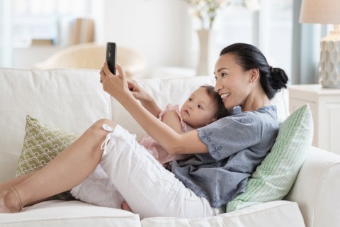 Mother taking selfie with baby daughter