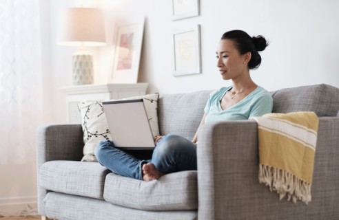 Japanese woman using laptop on sofa