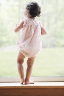 Mixed race girl looking out window