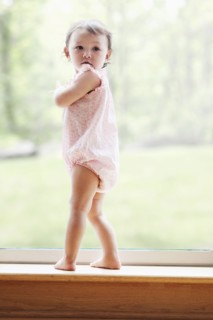Mixed race girl standing at window