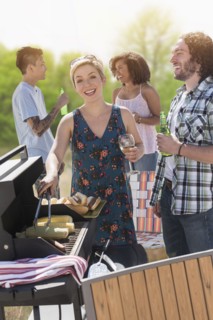 Woman serving hot dogs at barbecue
