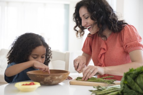 Mother and daughter chopping vegetables