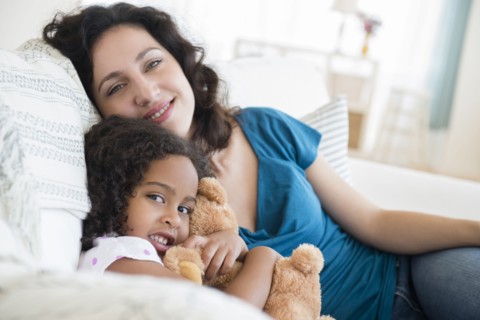 Mother and daughter sitting on sofa
