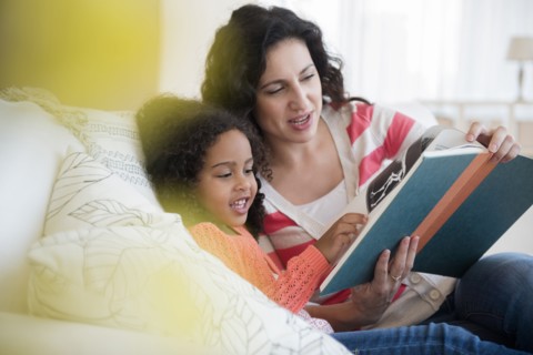 Mother and daughter reading on sofa