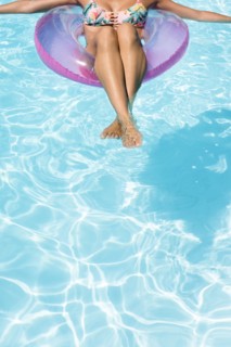 Caucasian woman floating in swimming pool