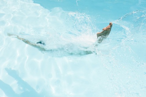 Caucasian woman diving in swimming pool