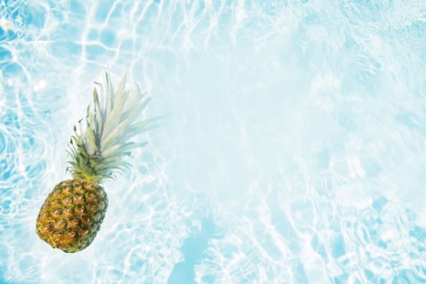 Pineapple floating in swimming pool