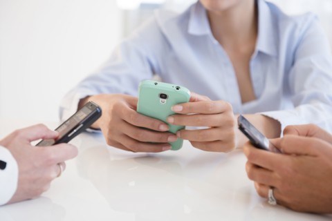 Business people using cell phones in office