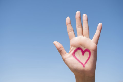 Hispanic woman with heart on hand