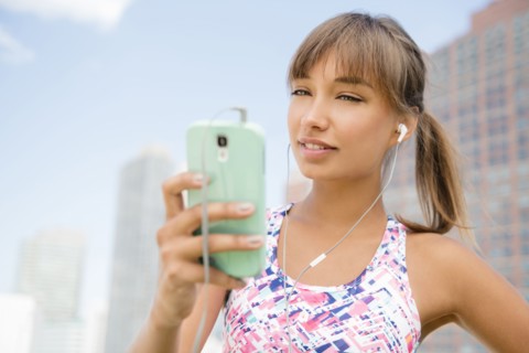 Mixed race woman listening to earbuds