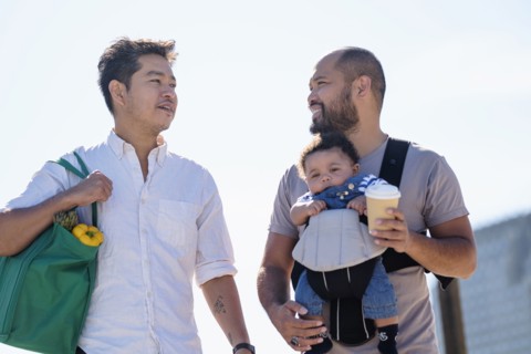 Gay fathers doing errands with baby son