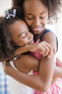 Mixed race sisters hugging