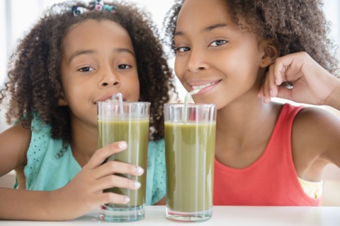 Mixed race sisters drinking healthy juice
