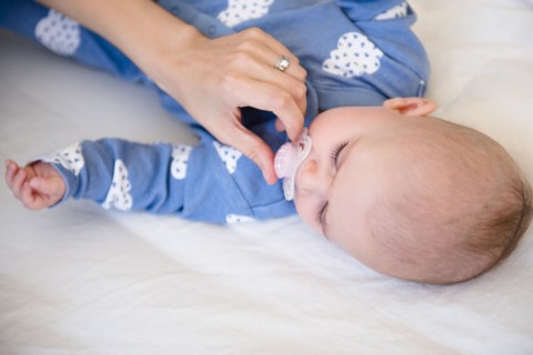 Caucasian mother giving baby daughter pacifier