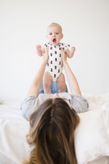 Caucasian mother holding baby daughter on bed