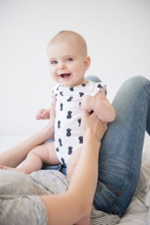 Caucasian mother holding baby daughter on bed