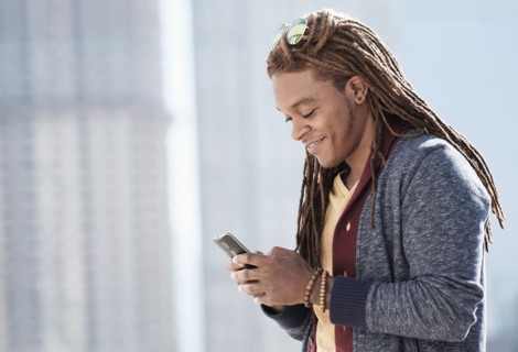 Mixed race man using cell phone outdoors
