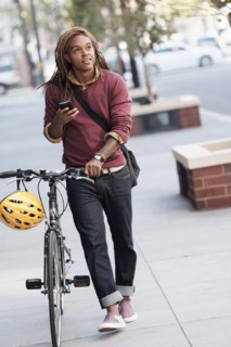 Mixed race man pushing bicycle outdoors