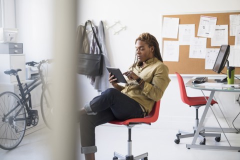 Mixed race businessman using digital tablet in office