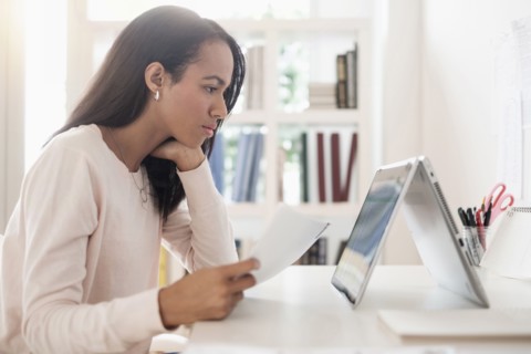 Mixed race businesswoman using laptop