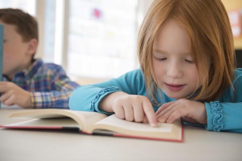 Caucasian student reading in classroom