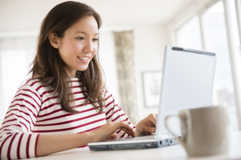Mixed race woman using laptop
