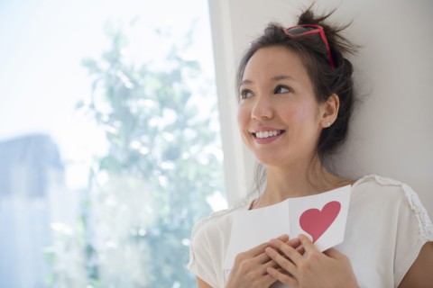 Mixed race woman holding Valentine card
