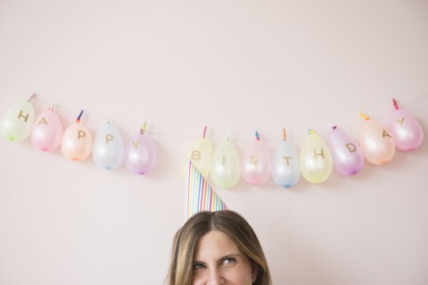 Caucasian woman wearing party hat at birthday
