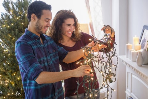 Couple untangling Christmas lights
