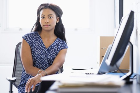Mixed race businesswoman sitting at desk