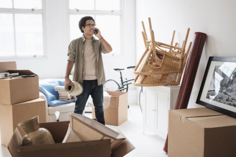 Mixed race man unpacking in new home