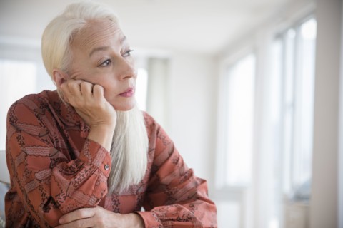 Caucasian woman sitting with chin in hand