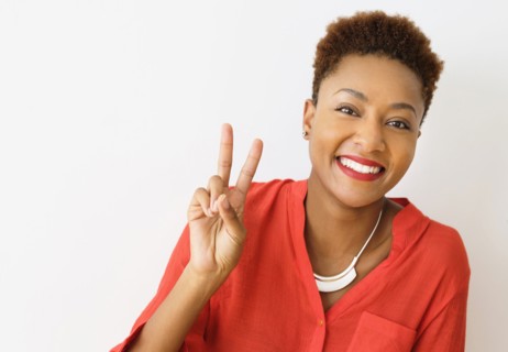 Mixed race woman making peace sign